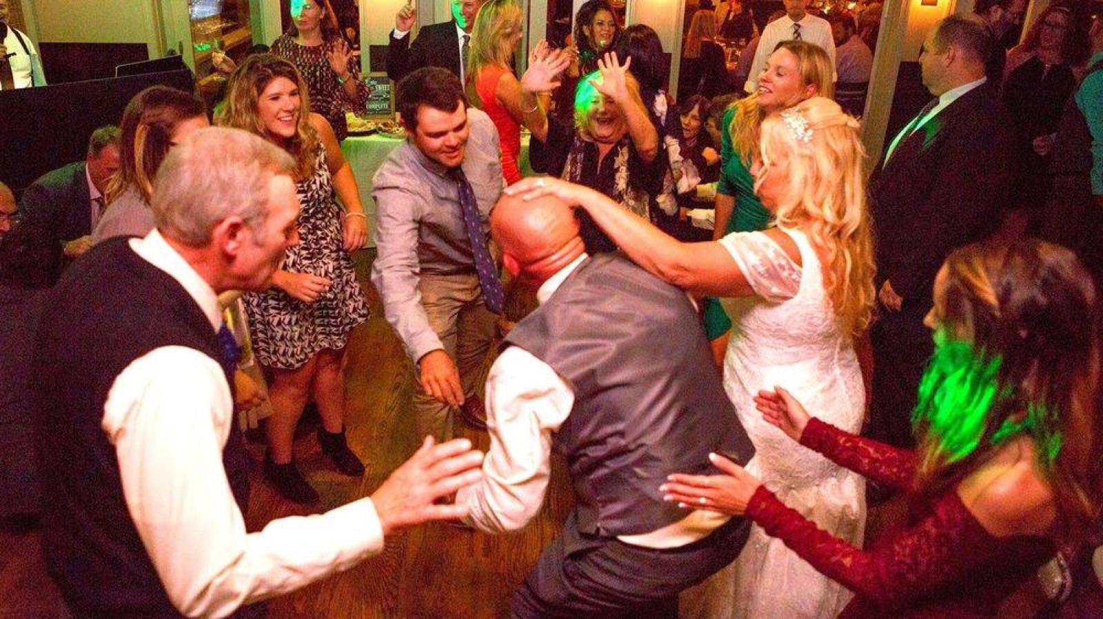 Guests dancing close together under colorful lights